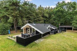 una piccola casa nera in mezzo a un cortile di HA178-Hals-Lyngtoftegaard-2 a Hals