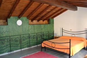 um quarto com uma cama laranja numa parede verde em Castelmilazzo em Milazzo