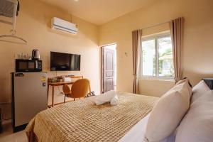 a bedroom with a bed and a desk and a television at Peridot Pool Beach in Chaweng Noi Beach