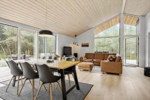 una sala da pranzo e un soggiorno con tavolo e sedie di OH522-Hadsund-Vidjeparken-18 a Hadsund Altre 18 foto