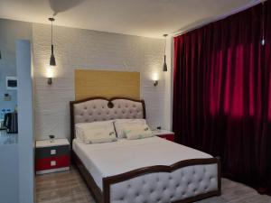 ein Schlafzimmer mit einem großen Bett und einem roten Vorhang in der Unterkunft Jewel's Hotel in Polomolok