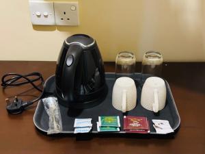 a table with a tray with a computer mouse and two glasses at NILGIRA VILLA By LILYS in Badulla