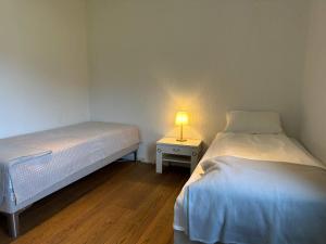 zwei Betten in einem Zimmer mit einer Lampe auf einem Tisch in der Unterkunft 4 star holiday home in Eidsvåg in Eidsvåg