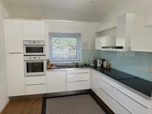 eine weiße Küche mit weißen Schränken und einem Fenster in der Unterkunft 4 star holiday home in Eidsvåg in Eidsvåg