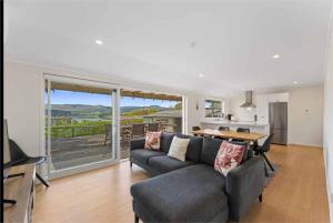 ein Wohnzimmer mit Sofa und Tisch in der Unterkunft Modern Lake View House in Mangakino