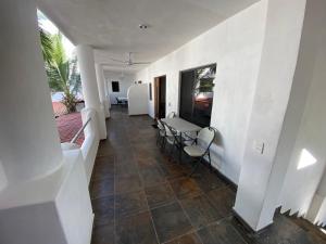 einen Flur mit weißen Wänden sowie einem Tisch und Stühlen in der Unterkunft Costa Ayala - Bungalow 5 with 2dbl beds and 1 sofa in Los Ayala