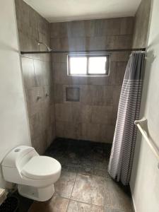 ein Badezimmer mit Toilette und Dusche in der Unterkunft Costa Ayala - Bungalow 5 with 2dbl beds and 1 sofa in Los Ayala