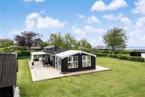 een zwart tiny house met een terras in een yard bij OH208-Hadsund-Haslevgaarde-Bakker-66 in Hadsund +18 foto's
