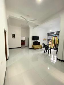 een grote woonkamer met een tafel en stoelen bij Diyaluma Villa Resort in Koslanda