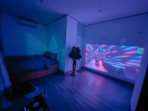 a room with a bed and a large screen television at Mộc Châu House in Mộc Châu