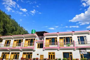 a large white building with yellow and blue windows at Barot Palace in Barot 