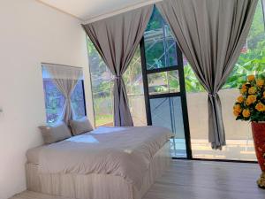 a bedroom with a bed in front of a large window at Mộc Châu House in Mộc Châu
