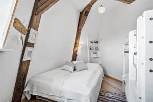 een bed in een kamer met witte muren en houten balken bij OH300-Hadsund-Ved-Mollen-3 in Hadsund