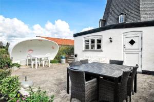 een terras met een tafel en stoelen voor een huis bij OH300-Hadsund-Ved-Mollen-3 in Hadsund