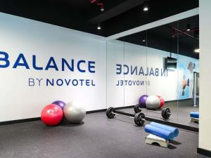 een sportschool met halters en ballen voor een muur bij Novotel Dubai World Trade Centre in Dubai