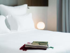 einen Stapel Bücher, die auf einem Bett liegen in der Unterkunft Zamzam Pullman Makkah in Mekka