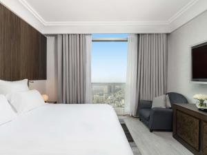 ein Hotelzimmer mit einem großen Bett und einem Fenster in der Unterkunft Zamzam Pullman Makkah in Mekka