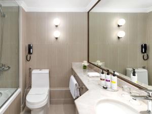 ein Badezimmer mit Toilette, Waschbecken und Spiegel in der Unterkunft Zamzam Pullman Makkah in Mekka + 94 Fotos