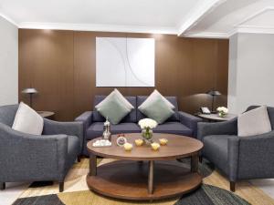 ein Wohnzimmer mit Sofa, Stühlen und einem Tisch in der Unterkunft Zamzam Pullman Makkah in Mekka
