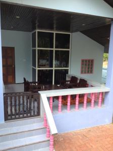 eine Veranda eines Hauses mit rosa Geländer in der Unterkunft Blue Beach Bungalow in Bang Saphan Noi