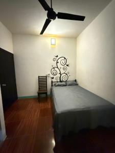 una camera da letto con un letto e un ventilatore a soffitto di Casa Roca a Zipolite