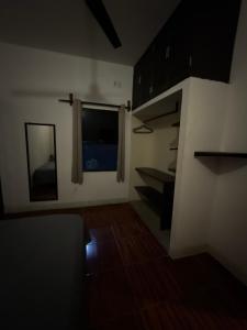 un soggiorno con una finestra e alcuni scaffali di Casa Roca a Zipolite