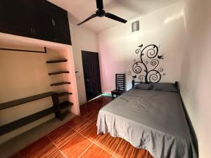 una camera da letto con un letto e un ventilatore a soffitto di Casa Roca a Zipolite