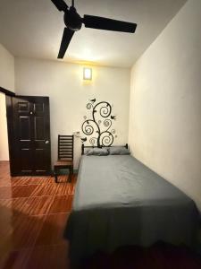 una camera da letto con un letto e un ventilatore a soffitto di Casa Roca a Zipolite