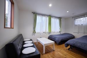 une pièce avec un canapé, un lit et une table dans l'établissement Casa Allegra, à Yamanakako