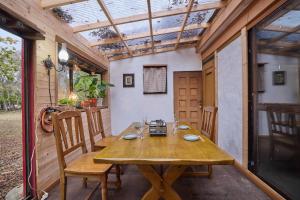 une table et des chaises en bois sur une terrasse avec un toit dans l'établissement Casa Allegra, à Yamanakako