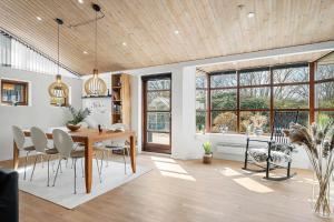 una sala da pranzo con tavolo, sedie e finestre di HA370-Saeby-H-C-Gads-Vej-5 a Sæby