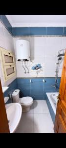 a bathroom with a toilet and a sink and a tub at عماره 11 in 6th Of October