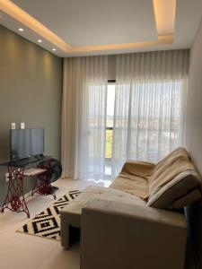 a bedroom with a bed and a tv and a window at Ap 304 Via Mares do Frances in Marechal Deodoro