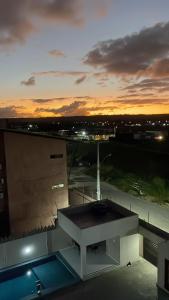 a view of a building with the sunset in the background at Ap 304 Via Mares do Frances in Marechal Deodoro