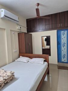 a bedroom with a bed with wooden cabinets and a fan at STM StayInn in Nāttarasankottai