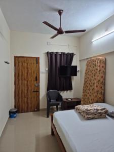 a bedroom with a bed and a ceiling fan at STM StayInn in Nāttarasankottai +2 photos