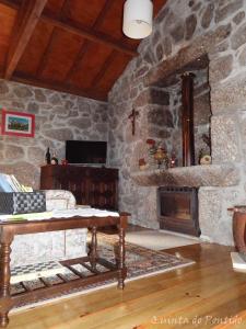 a stone room with a table and a fireplace at Quinta do Pontido in Vieira do Minho