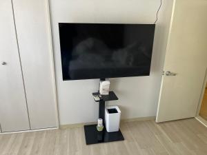 een grote flatscreen-tv aan een muur bij Shinehouse2 in Kawaguchi