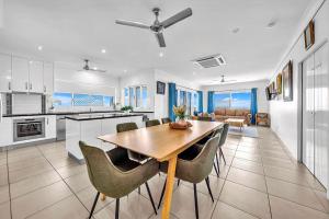una cucina e una sala da pranzo con tavolo e sedie di Panoramic Oceanview Villa a Bowen