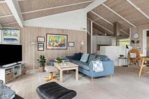 een woonkamer met een blauwe bank en een tafel bij HA390-Saeby-Graevlingestien-5 in Grønsig