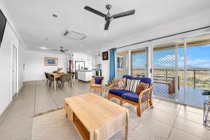 un soggiorno con un divano e un tavolo di Panoramic Oceanview Villa a Bowen Altre 23 foto