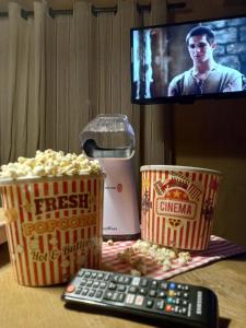een tafel met popcorn, een afstandsbediening en een tv bij Casa Terras de Minas in Gonçalves