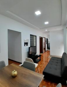 a living room with a black couch and a table at Suite cerca de la UTPL y Centro Histórico in Loja