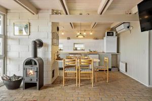a kitchen with a stove and a table with chairs at 300-Harboore-Fourmivej-29 in Harboør