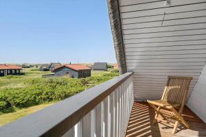 a chair sitting on a porch with a view of a house at 300-Harboore-Fourmivej-29 in Harboør