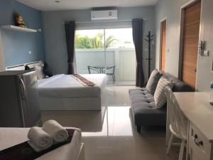 een hotelkamer met twee bedden en een bank bij Khao Oat airport in Nai Yang Beach +25 foto's