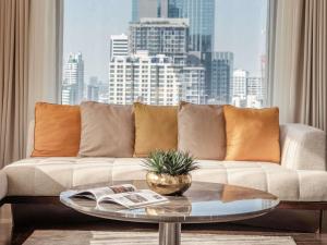 un salon avec un canapé et une grande fenêtre dans l'établissement VIE Hotel Bangkok - MGallery Collection, à Bangkok 124 autres photos