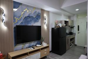 ein Wohnzimmer mit einem großen Flachbildfernseher an der Wand in der Unterkunft Eirene Place Relax and Recharge in Pusok