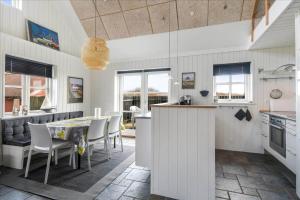 een keuken en eetkamer met een tafel en stoelen bij 715-Thyboron-Limfjordsvej-17-a in Thyborøn +19 foto's