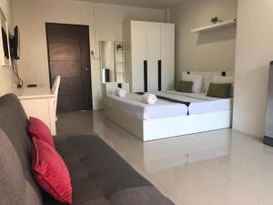 een woonkamer met twee bedden en een bank bij Khao Oat airport in Nai Yang Beach